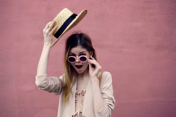 Bella donna per strada indossando cappello e occhiali modello da parete rosa — Foto Stock