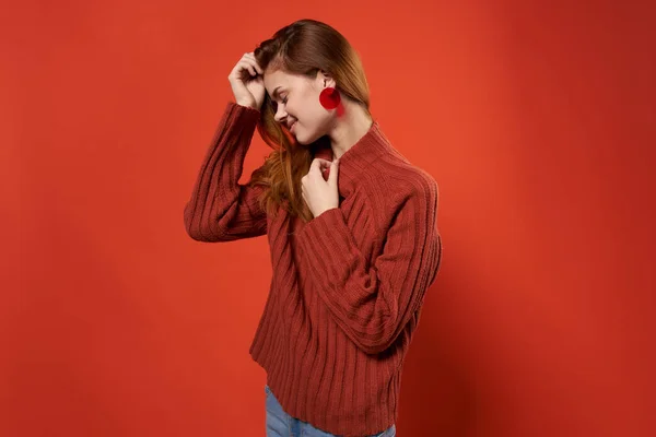 Mooie vrouw mode haarstijl oorbellen sieraden rode achtergrond — Stockfoto