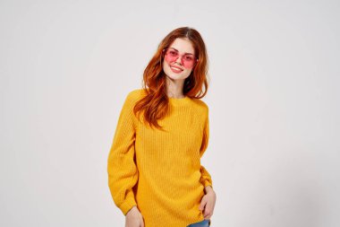 Süveter ve gözlüklü bir kadının portresi.