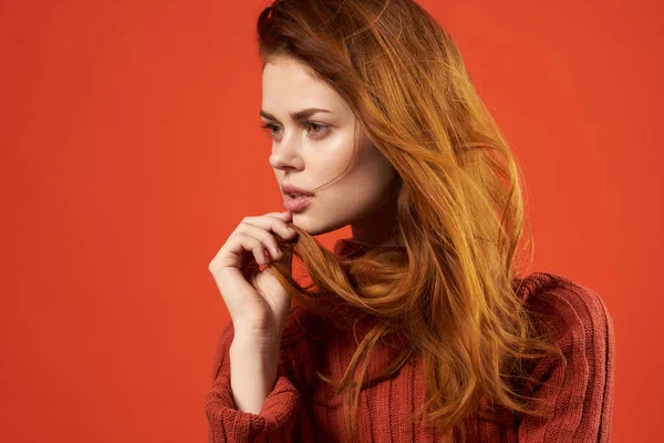 Рыжая женщина в красном свитере в модной студии позирует — стоковое фото