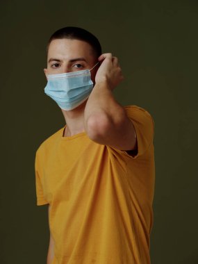 Tıbbi maskeli bir adam ellerini arka plan aşısı üzerine koyar ve pasaport yapar.