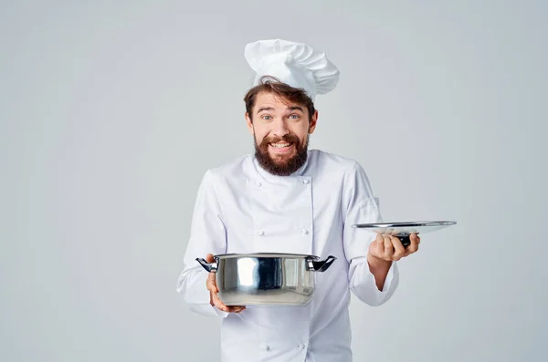 Chef profissional com uma panela em suas mãos trabalhando na cozinha — Fotografia de Stock