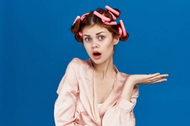 Kafasında bigudileri olan kadın ev hanımı duyguları mavi arka plan
