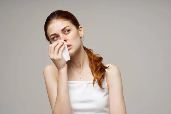 Zieke vrouw in wit t-shirt met een sjaal geïsoleerde achtergrond — Stockfoto