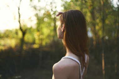 Beyaz elbiseli kadın doğa orman ağaçları yaz yürüyüşü