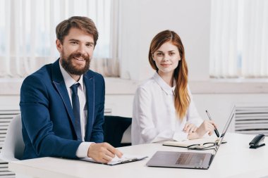 Meslektaşlar dizüstü bilgisayar uzmanları teknolojisinin önünde konuşuyor.