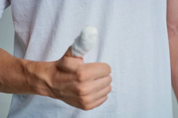 Mężczyzna pacjent zabandażowany ręka uraz palce lekkie tło — Zdjęcie stockowe