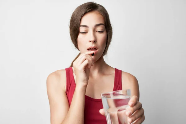 Vrouw in rood t-shirt geneeskunde gezondheidsproblemen therapie — Stockfoto