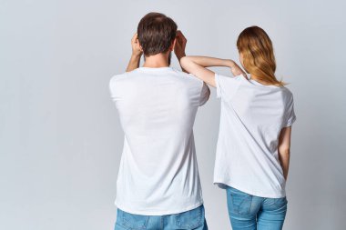 Erkek ve kadın beyaz tişörtler içinde kucaklaşıyorlar. Arka görünümü taklit ediyorlar.