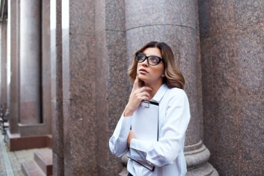 Dışarıdaki takım elbiseli kadın, elinde belgelerle izole edilmiş arka planda.