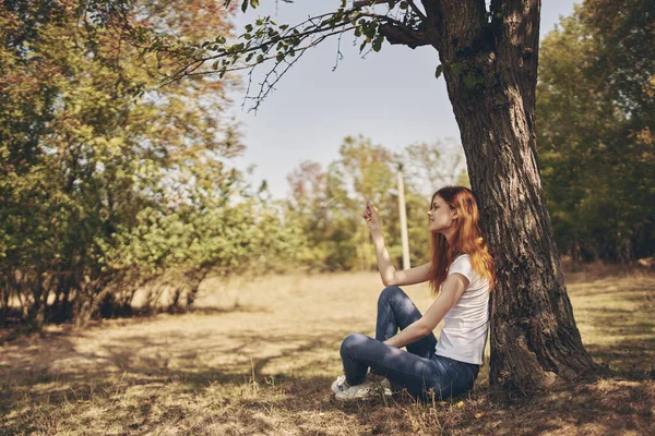 Mujer sentada cerca de un árbol naturaleza estilo de vida verano —  Fotos de Stock