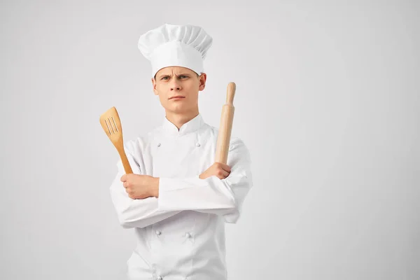 Chef di sesso maschile con un tappo sulla testa e stoviglie sfondo leggero — Foto Stock