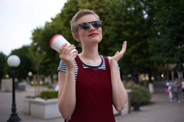Kvinna med kort hår på gatan bär solglasögon — Stockfoto