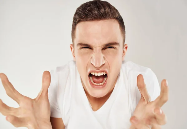 Dühös férfi fehér pólóban érzelem nemtetszés közelkép — Stock Fotó
