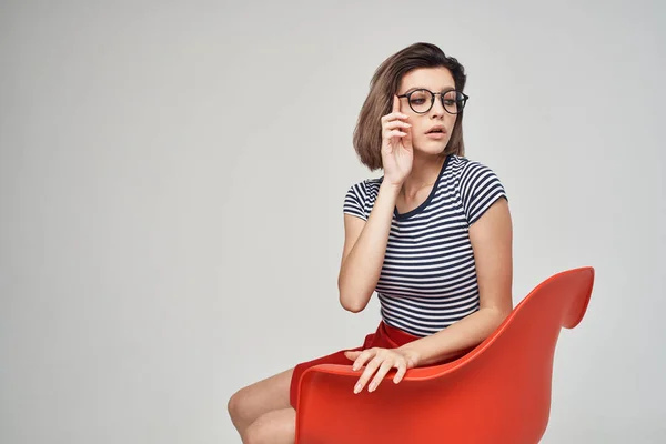 Kırmızı Sandalyede Oturan Şık Elbiseli Güzel Bir Kadın Yüksek Kalite — Stok fotoğraf