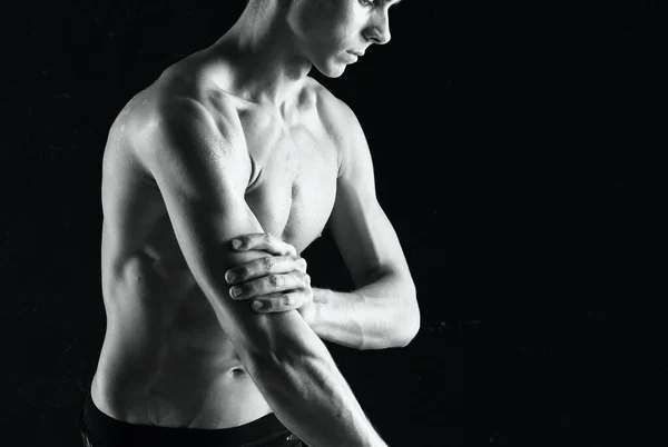 Homem com halteres nas mãos bombeando exercícios musculares — Fotografia de Stock