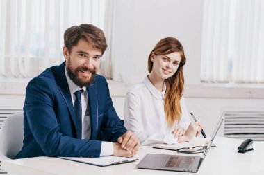 İş adamı ve kadın, dizüstü bilgisayarın önünde profesyonel teknolojinin önünde konuşuyor.