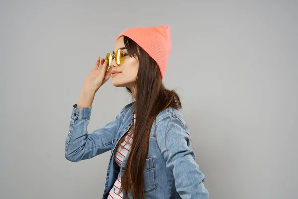 Mujer en rosa sombrero amarillo gafas casa hipster gris fondo — Foto de Stock