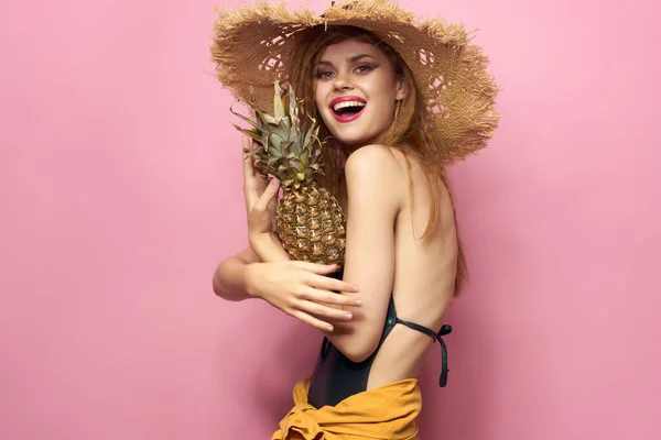 Vacker kvinna i halm hatt hålla frukt Exotisk rosa bakgrund — Stockfoto