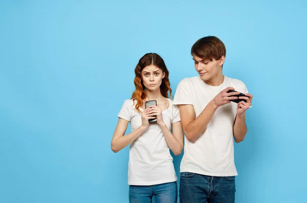 Giovane coppia con telefoni nelle mani aumento della tecnologia di comunicazione — Foto Stock
