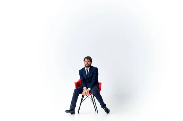Homem alegre Sentado no trabalho de escritório do gerente de cadeira vermelha — Fotografia de Stock