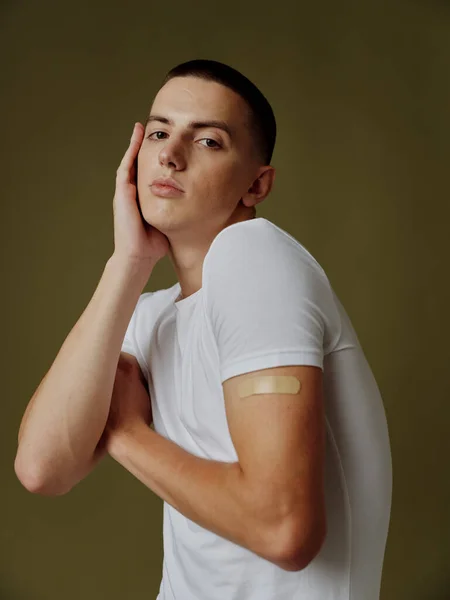 Rozrušený muž s lepicí omítkou na rameni hnědé pozadí vzor očkovací pas — Stock fotografie