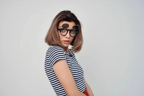 Femme portant des lunettes de mode rayé t-shirt fond clair glamour — Photo