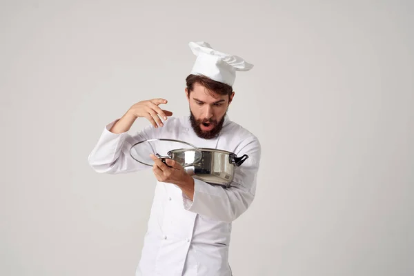 식탁에 놓인 접시를 손에 들고 요리하는 남자 요리사 — 스톡 사진