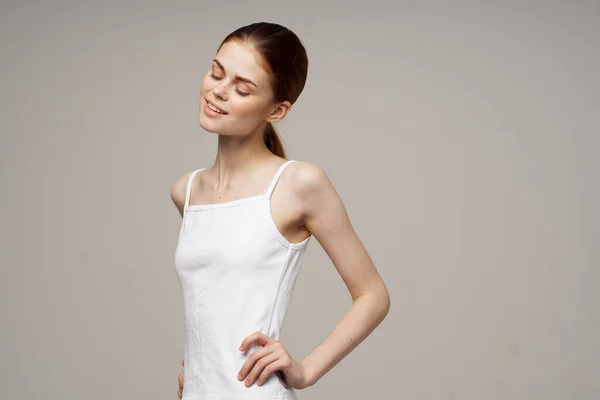 Vidám nő fehér pólóban bemelegítő ízületekkel — Stock Fotó