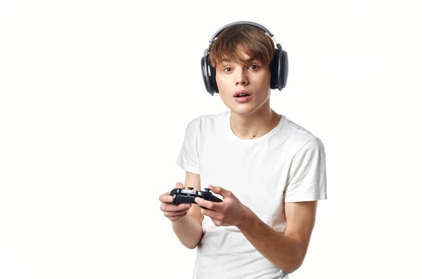 Man in een wit t-shirt in hoofdtelefoon met een joystick video games technologie gamer — Stockfoto