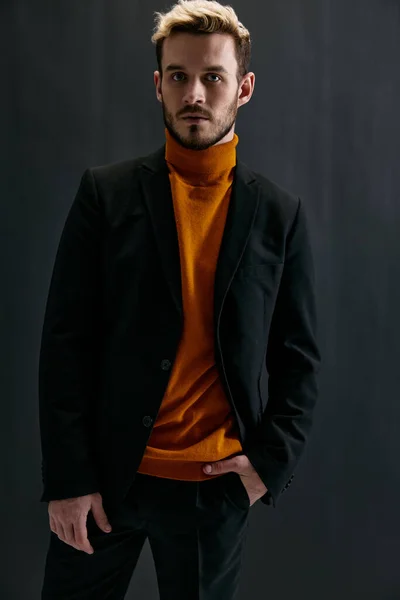 Chico en suéter naranja y chaqueta oscura sobre fondo gris modelo de vista recortada — Foto de Stock