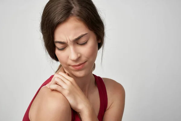 Kırmızı tişörtlü kadın eklem ağrısı, tatminsizlik sağlık sorunları — Stok fotoğraf