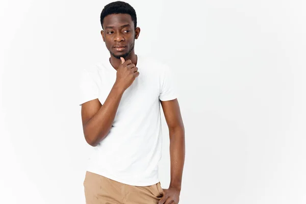 Apuesto hombre africano apariencia en blanco camiseta pensativo mirada luz fondo — Foto de Stock