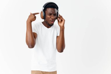 Kulaklıklı, müzik dinleyen, şaşırmış bir yüz ifadesi olan adam.