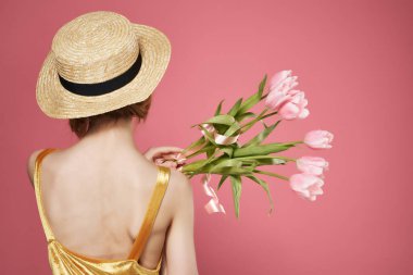 Bir buket çiçek takan kadın. Arka plan dekorasyonu. Pembe arka plan.