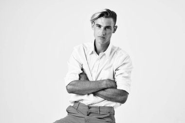 Beyaz gömlekli, saç stili, gülümseyen bir adam.