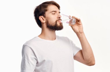 Beyaz tişörtlü, su dolu bir cam arka plan.