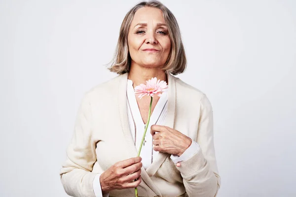 Starší žena držící květinový dárek k narozeninám — Stock fotografie
