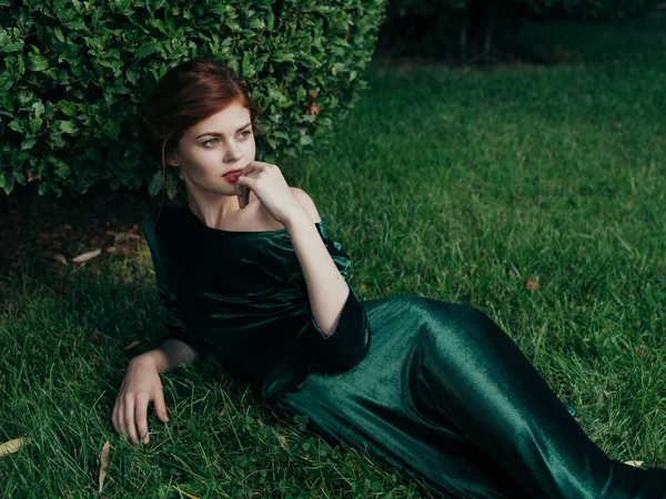 Csinos nő zöld ruhában és fekszik a kertben fantázia divat nyár — Stock Fotó