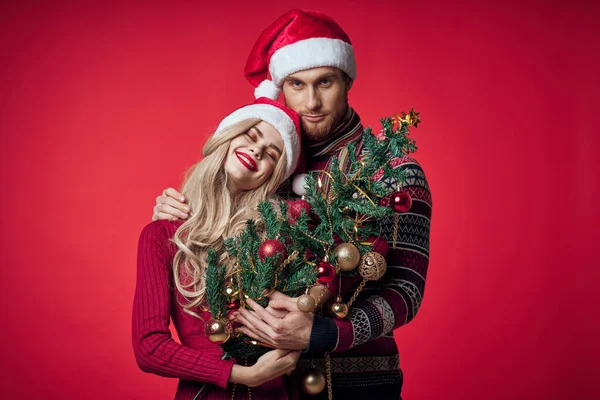 Mężczyzna i kobieta w nowym roku ubrania razem prezenty wakacje czerwone tło — Zdjęcie stockowe