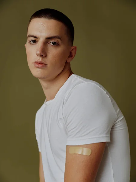 Λευκοπαστίρη στον ώμο ενός άνδρα διαβατήριο εμβολίου για ένεση covid- 19 — Φωτογραφία Αρχείου