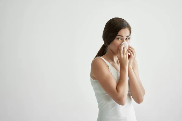 Donna in t-shirt bianca soffia il naso in un velo infezione freddo — Foto Stock