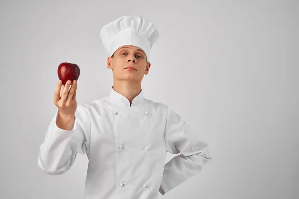 Homem com uma maçã nas mãos Chef uniforme trabalho profissional restaurante — Fotografia de Stock