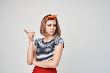 Kafasında turuncu bandajlı neşeli bir kadın duygusal modellik yapıyor.