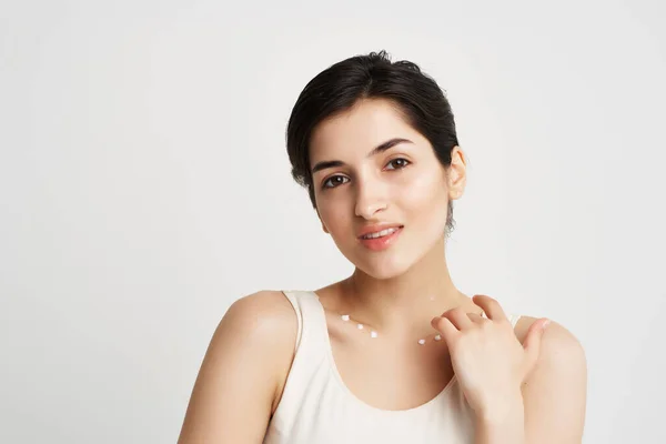 Mulher em t-shirt branca limpa pele creme maquiagem luz fundo — Fotografia de Stock