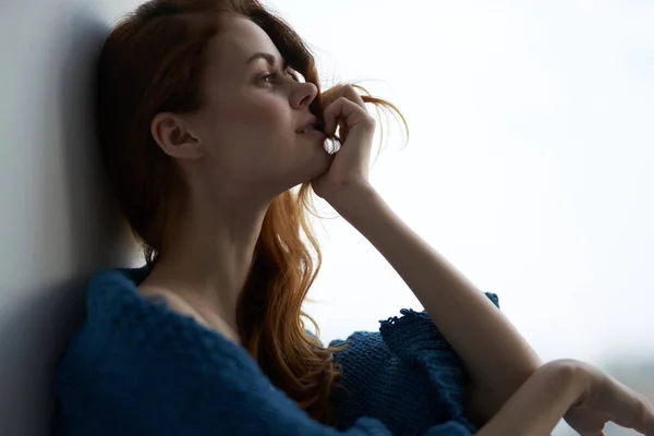 Ładna kobieta siedzi w pobliżu okna z niebieską kratę rano — Zdjęcie stockowe