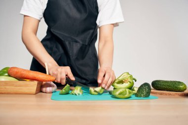 Şef mutfakta sebze doğruyor vitaminler ev işi yapıyor.