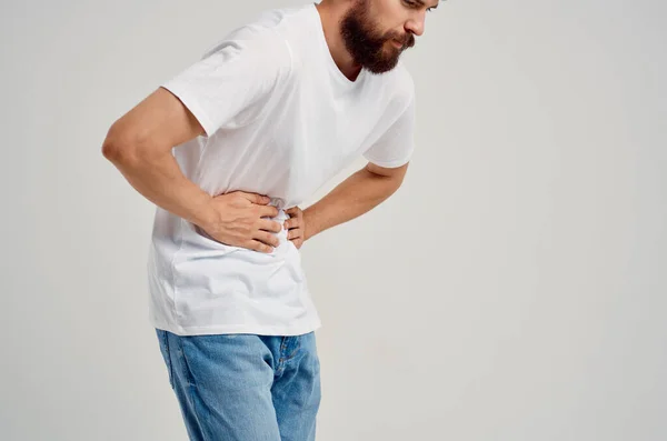 Homem barbudo vestindo t-shirt branca e segurando seu estômago problemas de saúde diarréia — Fotografia de Stock