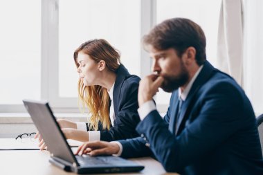 İş adamı ve kadın bir dizüstü bilgisayarın önünde oturuyor internet yetkilileri