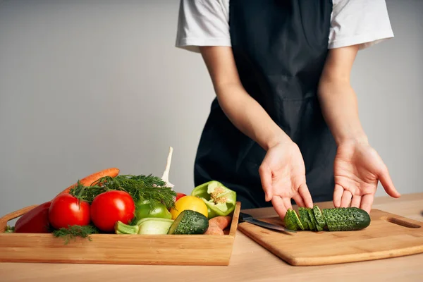 Chef en delantal negro rebanando verduras cocina cocina de cerca —  Fotos de Stock